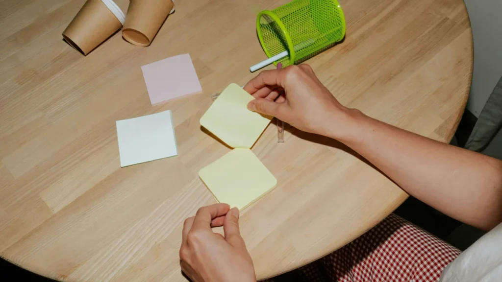 Alternatives to New Year's Resolutions Hands writing goals on post-it notes with coffee - Upper-intermediate ESL lesson on New Year's resolution alternatives