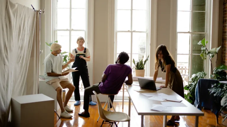 Small group of adults having a discussion in a bright room, perfect for a B1 storytelling lesson on personal narratives.