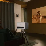 A couple watching a sci-fi movie at home with a projector — movies A2 lesson on film genres and movie night habits.