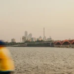 A cyclist rides along the Han River in Seoul with a bridge and city skyline behind — C1 lesson plan on the Korean Dream.