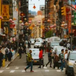 Busy Chinatown street with red lanterns and shop signs, the cover photo for this b1 english lesson on east and west culture.