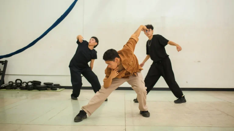 Three dancers rehearsing contemporary movement in a studio, used as the cover photo for the Dance and Tradition lesson plan.